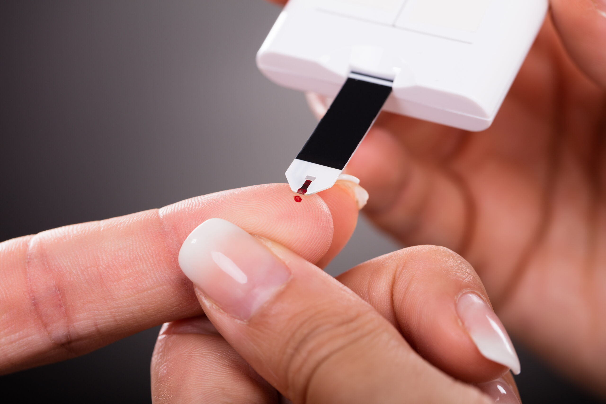 Doctor Checking Patient's Sugar Level With Glucometer