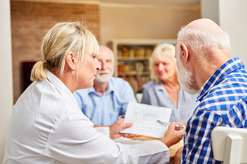 Ärztin betreut Senioren in einer Therapie Sitzung
